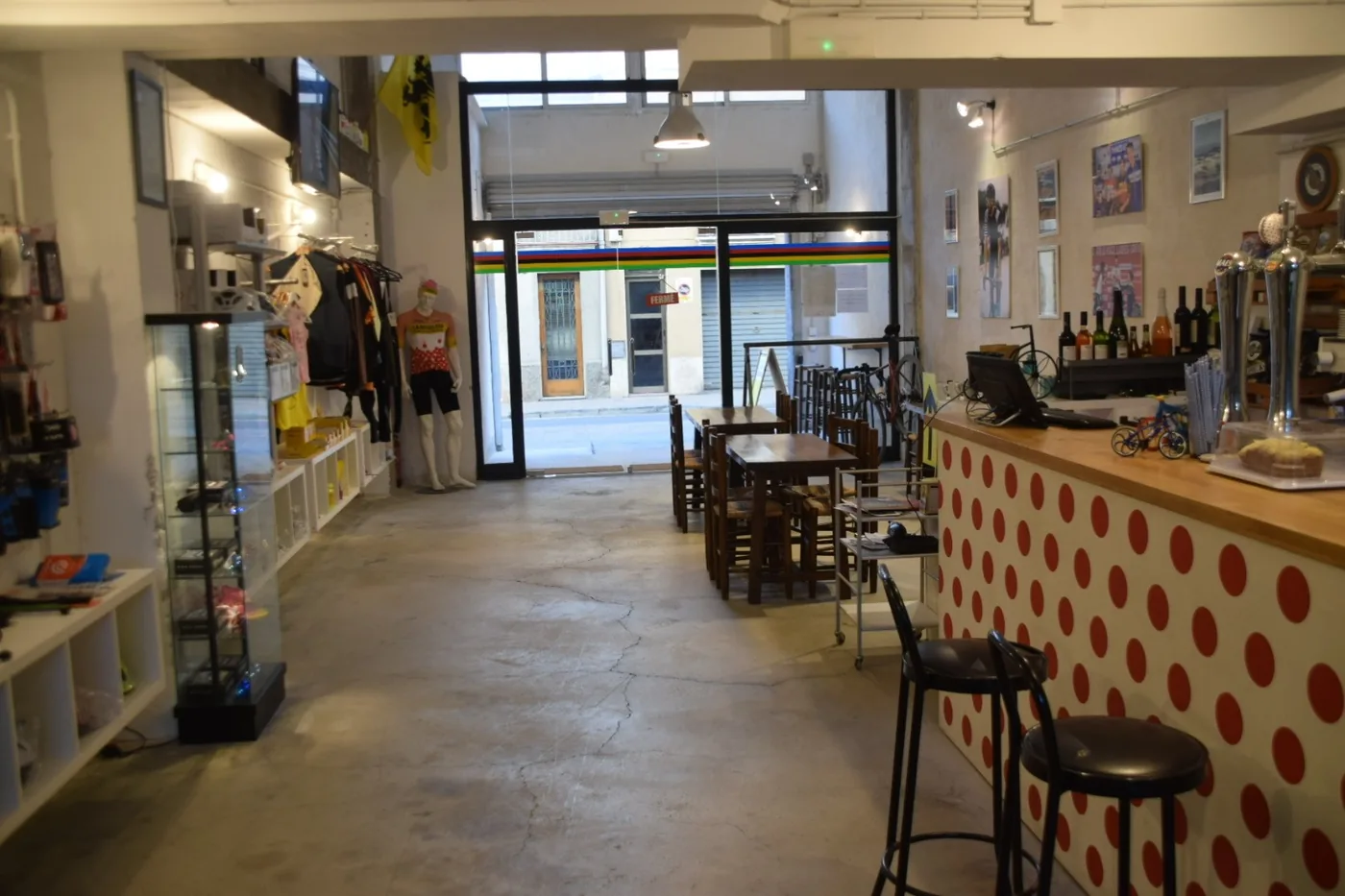 L'interior de La Biciclera amb la barra de llunes vermelles, els tamborets i les taules del fons.